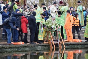 Священик опускає хрест у воду