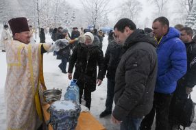 Священник освящает воду
