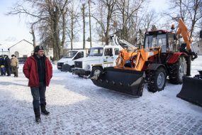 Мужчина проходит возле снегоуборочной техники