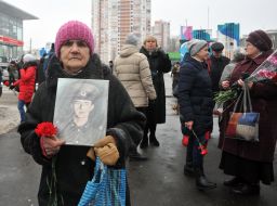 Relatives of warriors killed in Afghanistan hold their portraits