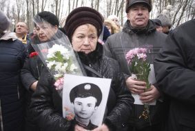 Relatives of warriors killed in Afghanistan hold their portraits