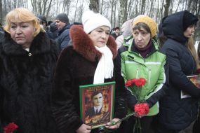 Relatives of warriors killed in Afghanistan hold their portraits