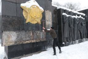 Unidentified people beat the slab at the Monument of Glory