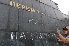 Unidentified people beat the slab at the Monument of Glory