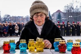 An elderly woman puts a candle