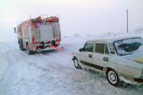 Rescuers pull the car out of a snowdrift