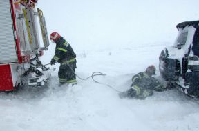 Rescuers pull the car out of a snowdrift