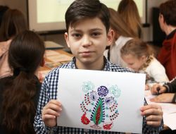 The boy shows a drawing