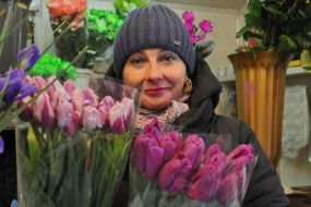 Жінка тримає букети тюльпанів