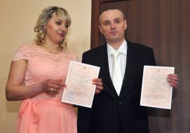 Newlyweds holding marriage certificates