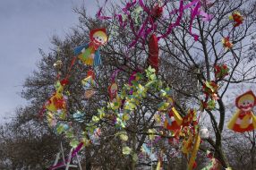 The tree is decorated with paper toys