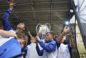 Children make selfie with cup of Champions League