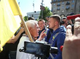 A man in an embroidered shirt is against the Labor March