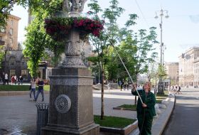 An employee watering a flower bed