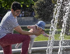 A man with a child near a fountain