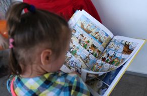 The girl looks at the book