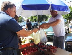 The seller hands the product in the plastic bag to the buyer