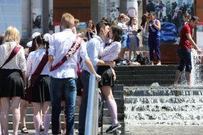 Выпускники целуются возле фонтана