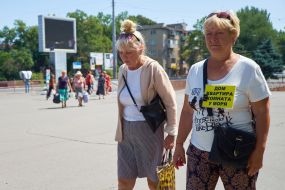 Woman with a sign "House, apartment, room by the sea"