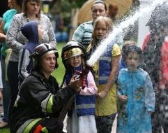 A girl and a lifeguard are holding a fire hose