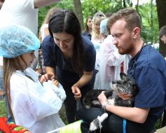 A girl in medical uniform examines a dog