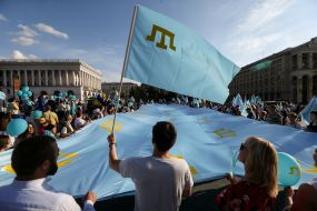 People keep the national flag of the Crimean Tatars