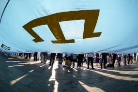 Люди тримають національний прапор кримських татар