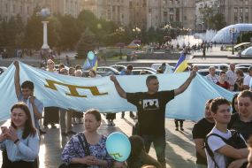 Люди тримають національний прапор кримських татар