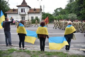 People with flags of Ukraine meet military