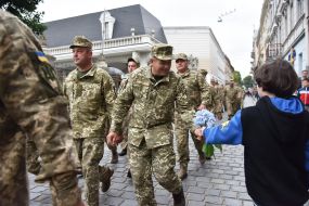 The boy gives flowers to the military 
