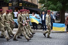People with flags of Ukraine meet military