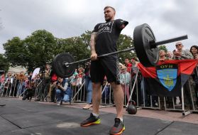 Участник соревнований "Игры Героев" поднимает штангу