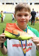 Юный футболист держит бутсы с автографом