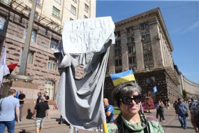 A woman holds a poster near the KCSA