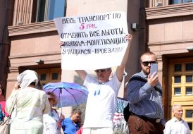 Мужчина держит плакат  возле КГГА