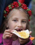 A girl in a Ukrainian wreath with a piece of cheese