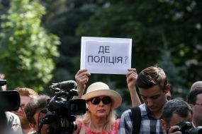 The participant of the action holds a poster with the inscription "Where is the police?"