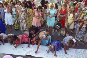 Participants of the "Women's Flashmobile" write wishes in the symbolic "Shoot of Peace"