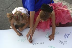 Participants of the "Women's Flashmobile" write wishes in the symbolic "Shoot of Peace"