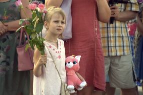 A girl with flowers and a soft toy