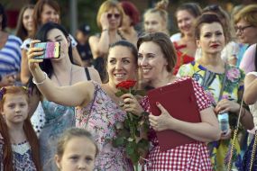 Participants in flash mob of femininity with flowers make selfie