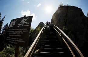 People climb the stairs to the rock