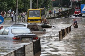 Машины движутся по затопленной улице