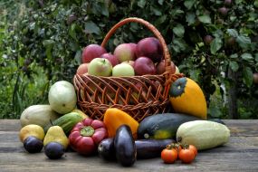 A basket of apples and fruit vegetables on the table