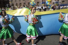 Girls in national costumes bear the Great State Flag of Ukraine