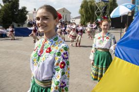 Girls in national costumes hold the flag of Ukraine