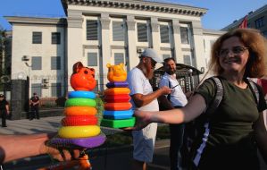 Активисты держат игрушечные пирамидки