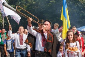 Participant of festive procession plays trembita