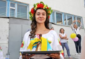 Старшеклассница держит колокольчик