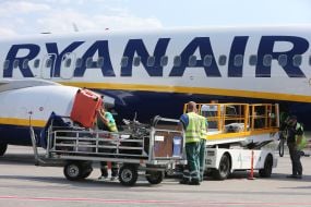 Airport staff unload baggage
